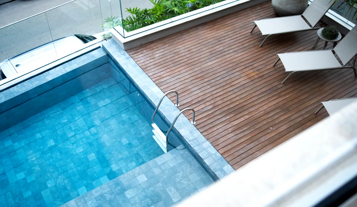 Piscina com deck de madeira e espreguiçadeiras